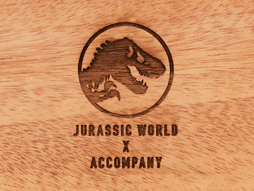 Wood-burned Jurassic World T. rex logo and JURASSIC WORLD X ACCOMPANY on a wooden tray
