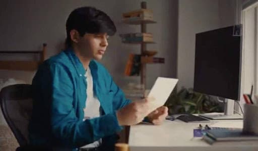 Sonu sits at his desk reading a letter in a scene from Letters of Love